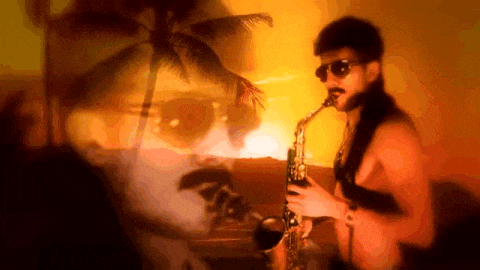a shirtless man playing a saxophone with a palm tree in the background