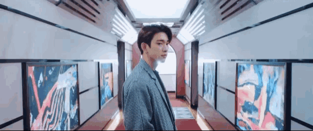 a man in a suit is walking down a hallway .