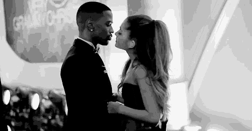 a man and a woman are kissing in front of a crowd .