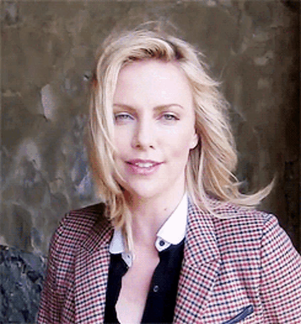 a blonde woman wearing a plaid jacket and a white shirt