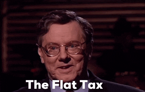 a man wearing glasses and a suit says " the flat tax " in front of him