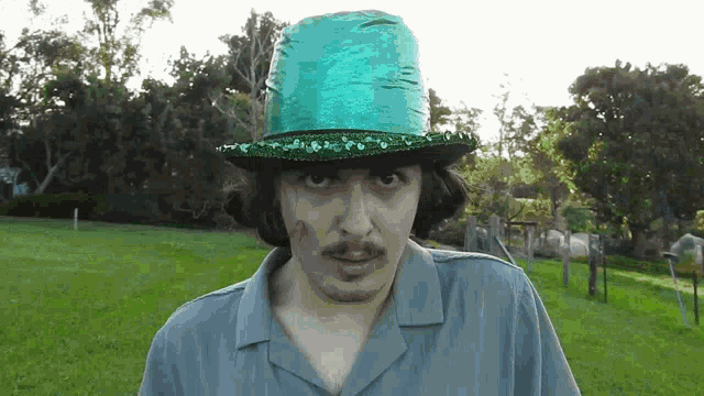 a man wearing a green top hat with sequins