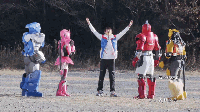 a man in a white shirt stands in front of a group of robots with chinese writing on the bottom
