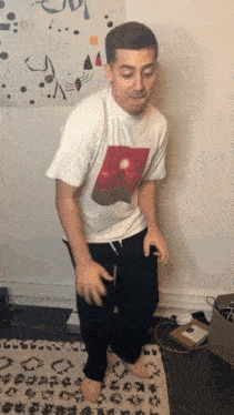 a man wearing a white t-shirt with a picture of the sun on it is dancing
