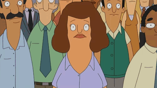 a woman in a blue shirt is standing in front of a crowd of people