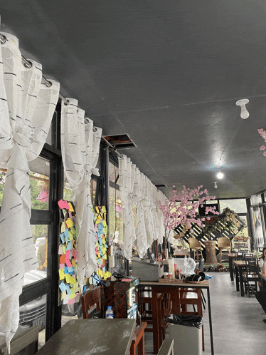 the inside of a restaurant with tables and chairs and sticky notes on the wall