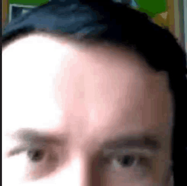 a close up of a man 's face with his eyes closed and his head visible .