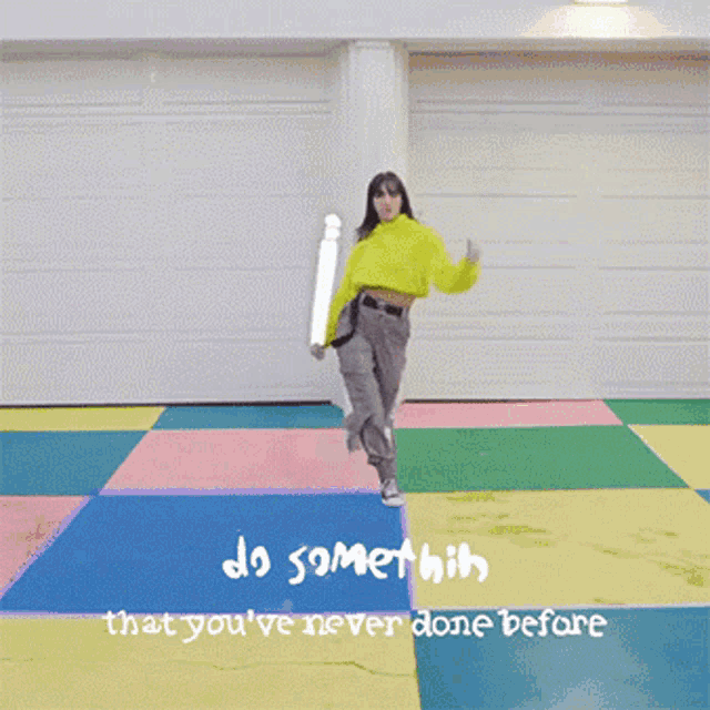 a woman in a yellow sweater is dancing on a colorful floor with the words " do something that you 've never done before "