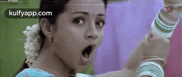 a close up of a woman 's face with her mouth open and bracelets on her wrists .