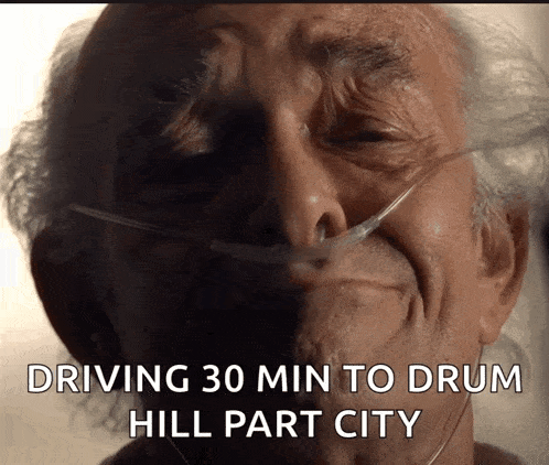 an elderly man with an oxygen tube in his nose is driving to drum hill part city