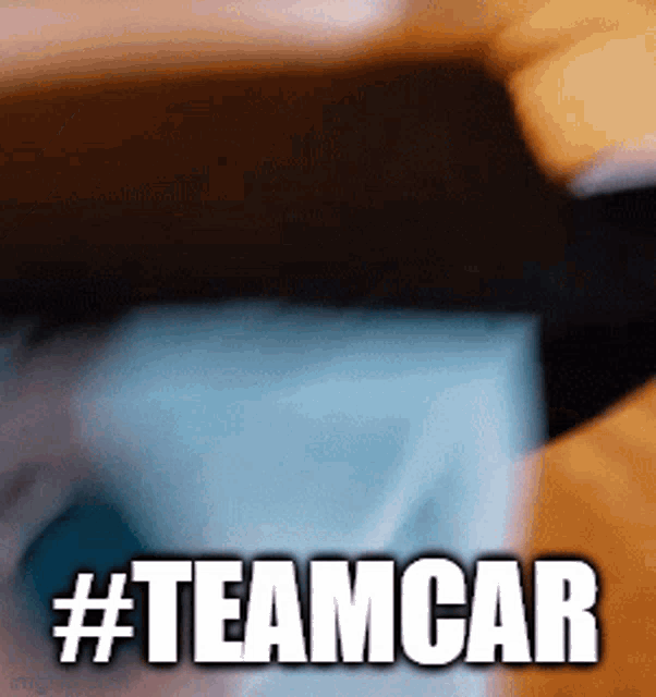 a gif of a person opening a box with the words #teamcar