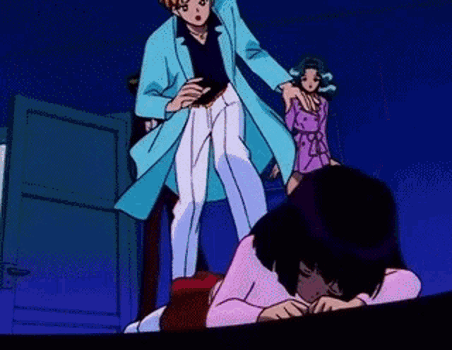 a man in a blue coat is standing next to a woman laying on a bed .