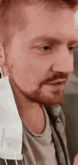 a close up of a man with a beard wearing a mask .