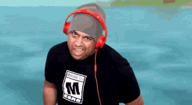 a man wearing headphones and a black shirt that says mature 17