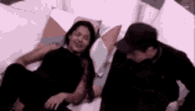a man and a woman are sitting on a couch and talking to each other .