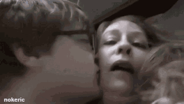 a man is kissing a woman on the cheek in a blurry photo .