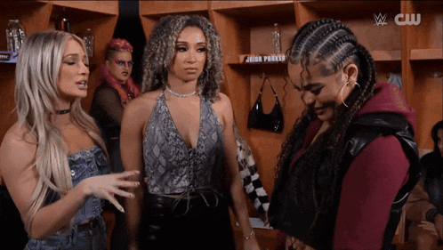 a group of women standing in a locker room with a cw logo on the bottom right