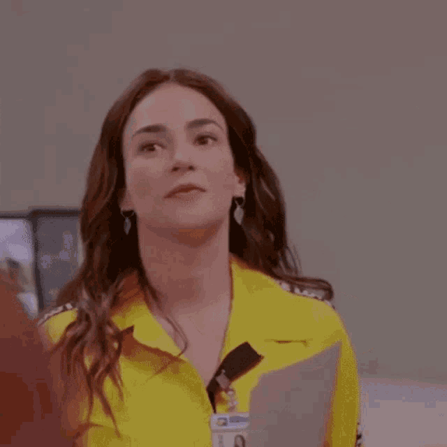 a woman wearing a yellow shirt and a name tag that says ' kitty ' on it