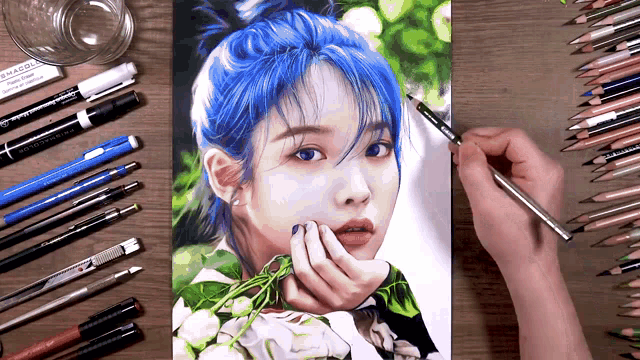 a drawing of a woman with blue hair is surrounded by colored pencils and pens
