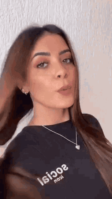 a woman wearing a black shirt and a necklace is making a face .