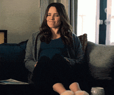 a woman sitting on a couch with her feet up