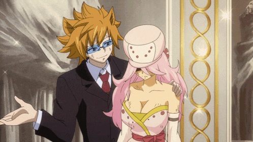 a man in a suit is standing next to a woman in a pink dress