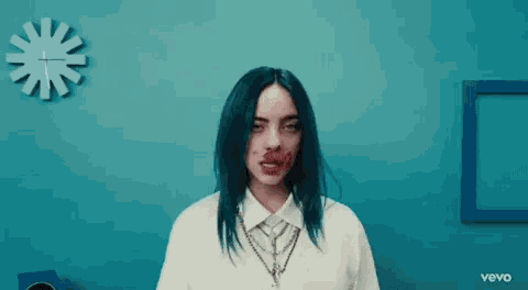 billie eilish is wearing a white shirt and tie and has red lipstick on her face .