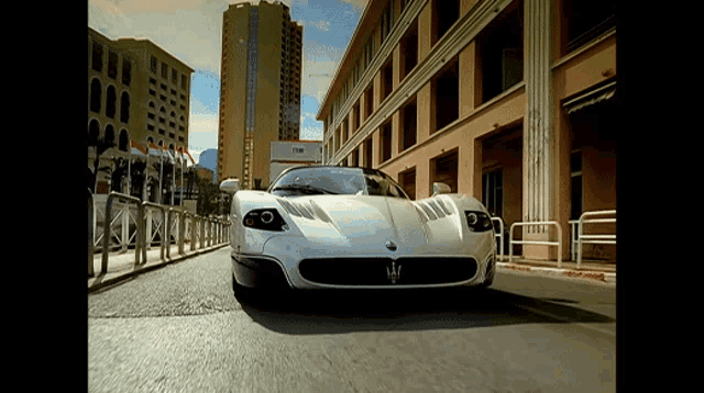 a white maserati sports car is driving down a street