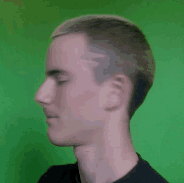 a young man with a shaved head and a black shirt