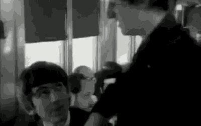 a black and white photo of two men standing next to each other in a room .