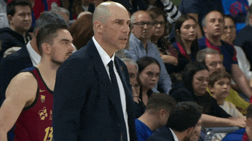 a man in a suit stands next to a basketball player wearing a jersey that says 13