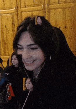 a woman wearing headphones is smiling in a video
