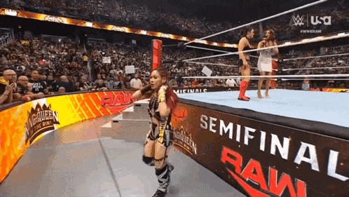 a woman in a wrestling ring with a sign that says semifinal raw