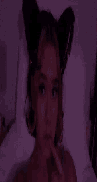 a close up of a person laying on a bed with purple lighting .