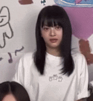 a girl with long black hair is wearing a white t-shirt with the word o on the front .