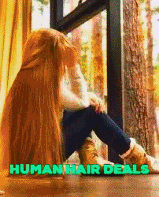 a woman with very long hair is sitting in front of a window with the words human hair deals written above her