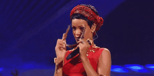 a woman in a red dress is holding a microphone .