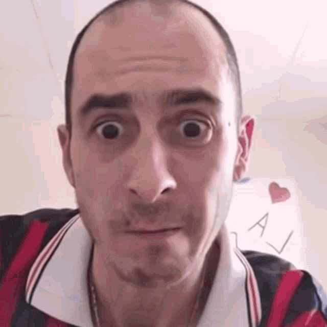 a man is making a funny face in front of a sign that says a