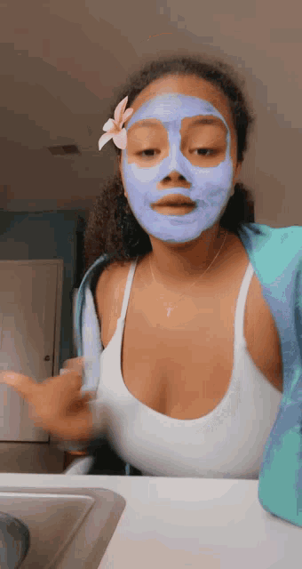 a woman wearing a purple face mask with a flower on her head