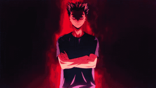 a man with his arms crossed is standing in a dark room