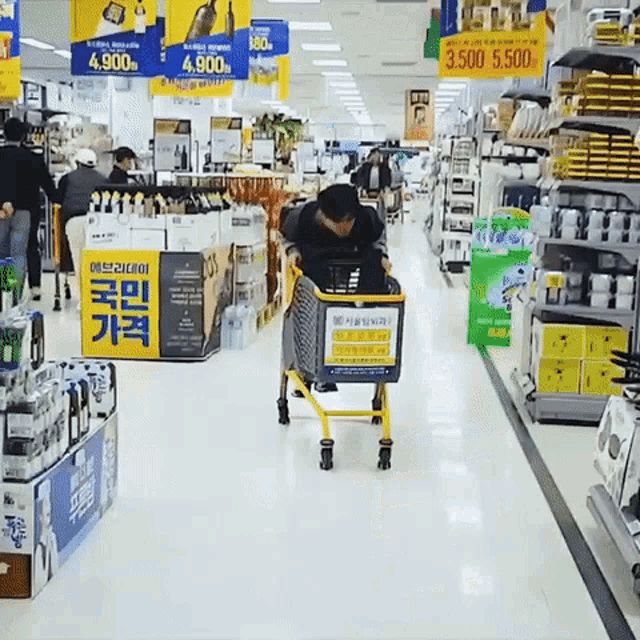 a man pushing a shopping cart in a grocery store with a sign that says 3,500 on it