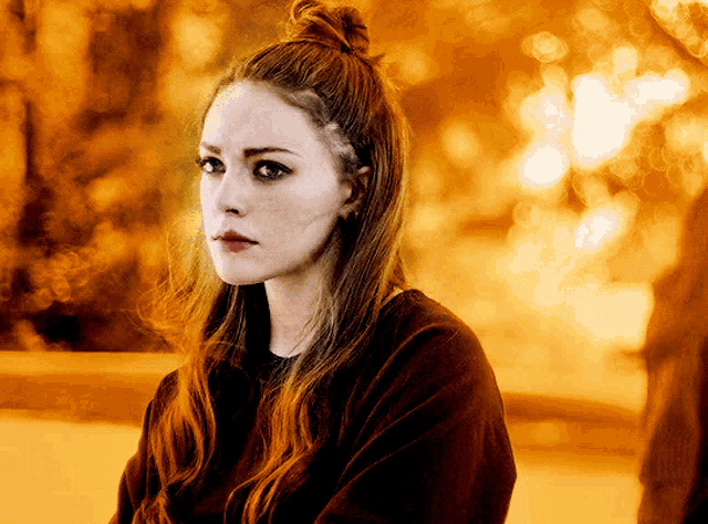 a woman with red hair and a bun on her head