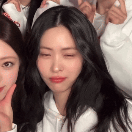 a girl with long black hair is making a funny face