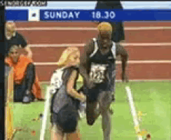 a runner on a track with a sign that says sunday 18:30