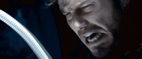 a close up of a man 's face with his eyes closed and his mouth open