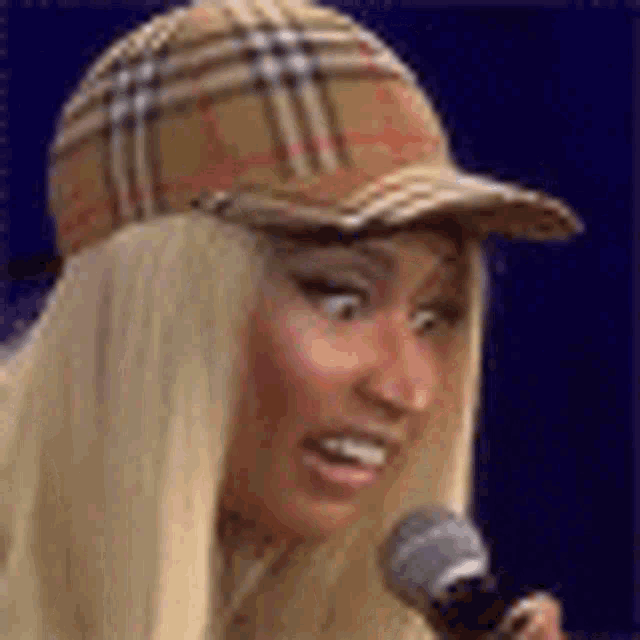 a woman wearing a plaid hat is holding a microphone .