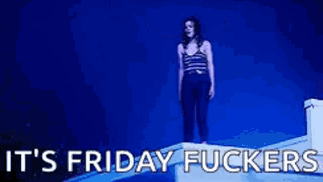 a woman is standing on top of a building with her arms in the air and the words `` it 's friday fuckers '' .