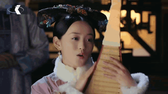 a woman playing a musical instrument with a blue circle behind her