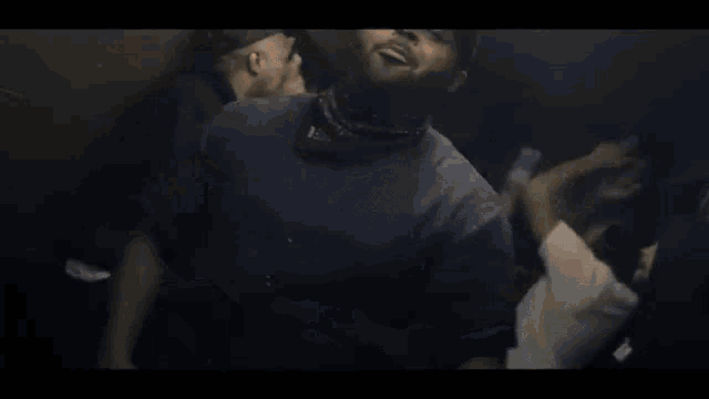 a man wearing a hat and headphones is dancing in a crowd of people .