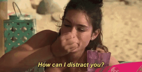 a woman is sitting on the beach with a drink in her hand and asking how can i distract you ?